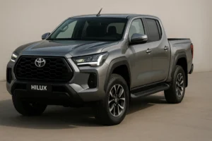 2026 Toyota Hilux pickup truck in metallic grey, shot in 3-quarter front angle, showcasing bold grille, LED headlights, muscular wheel arches, alloy wheels, premium exterior design