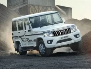 Mahindra Bolero 2025 parked on rural Indian road with chrome grille, LED headlights, bold SUV design.